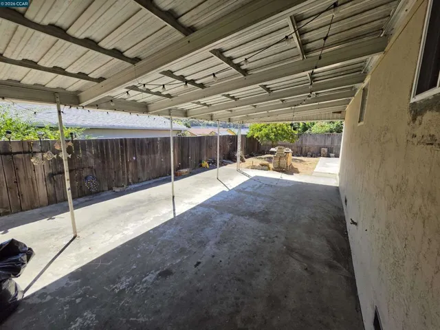 Covered patio area from garage to back side door of home. Also leads to the backyard.