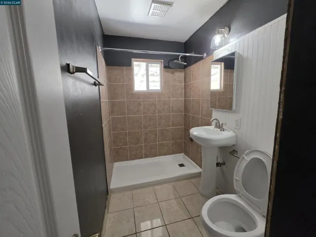 Bathroom 1 has a sink with a vanity mirror, a toilet, and a shower.