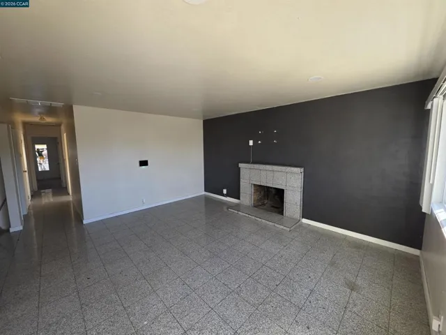 FRONT DOOR ENTERS THE LIVING ROOM WITH A FIREPLACE.