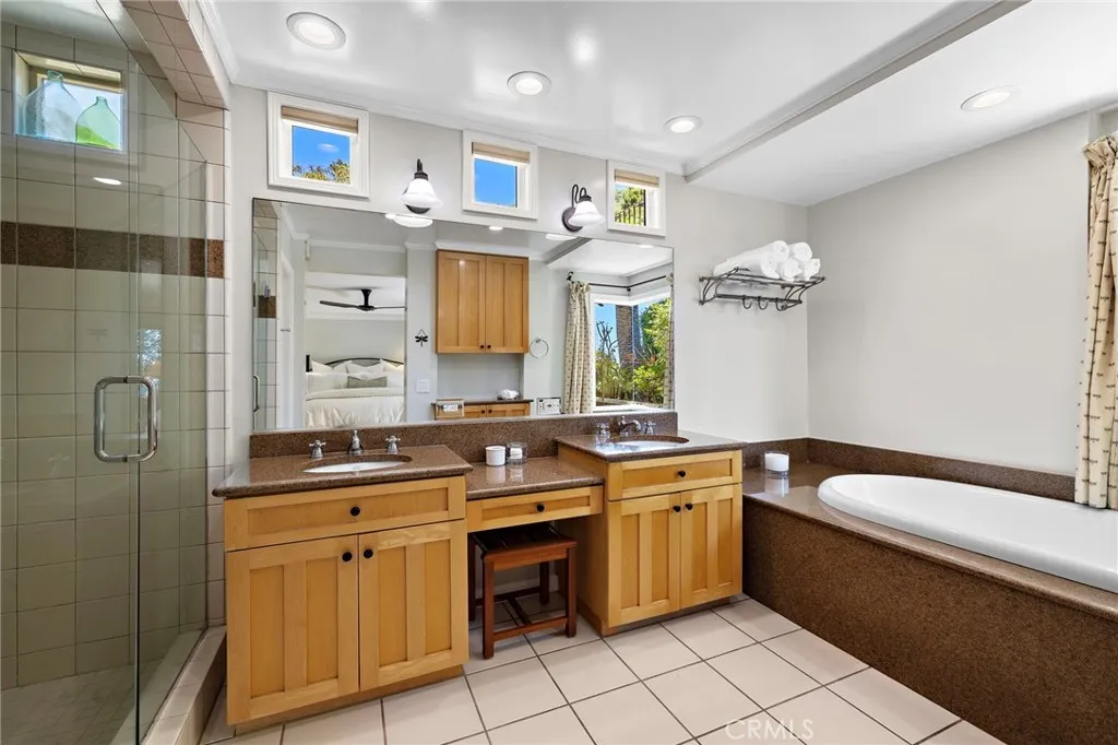 Spacious primary bath with a walk-in shower and jetted tub, complete with an ocean-view window above.