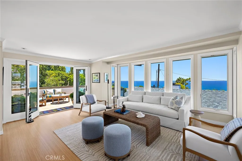 Living room with panoramic ocean views and french doors leading to the ocean view deck.