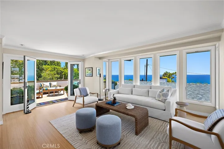 Living room with panoramic ocean views and french doors leading to the ocean view deck.