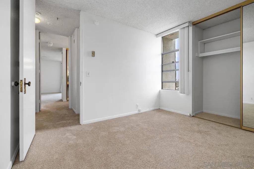 Looking back across the 2nd bedroom to the closet, window, and hall.