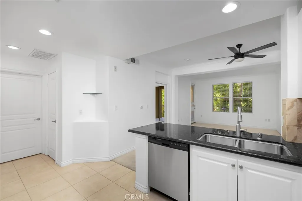 Thoughtfully designed kitchen features timeless white shaker cabinetry, low-maintenance quartz countertops, and stainless steel appliances.