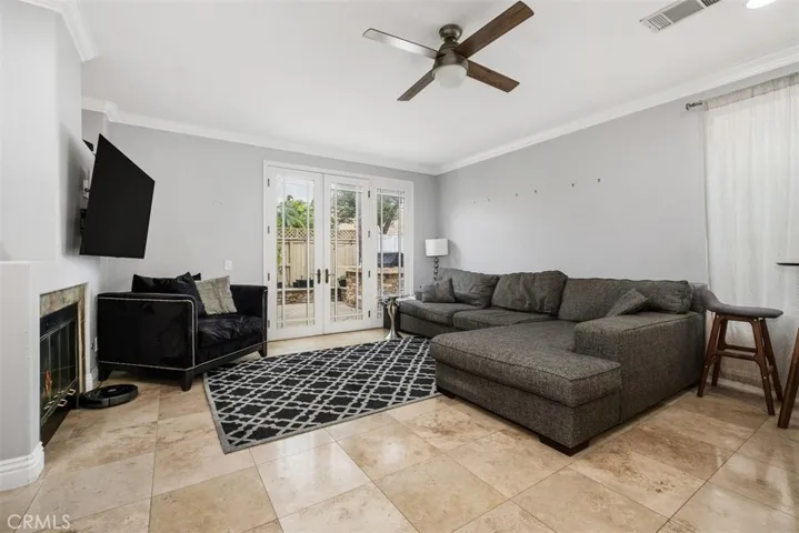 This family room has a gas fireplace and beautiful French doors leading to the backyard space