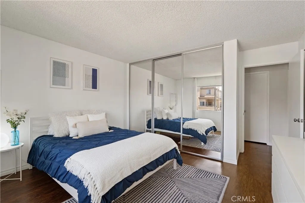Bedroom with mirrored closet doors and view of walk in hallway closet