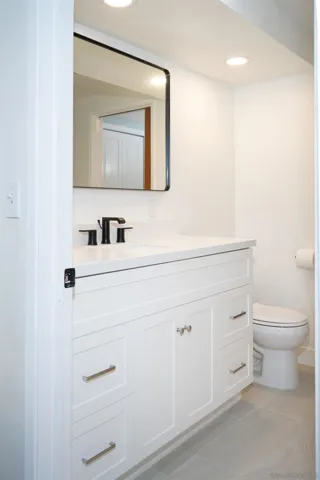This bathroom is attached to a secondary bedroom with a second door that opens to the laundry area.