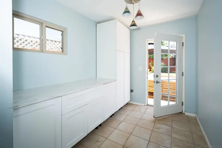 Laundry area connects to a bathroom/secondary bedroom and has a door to the backyard.