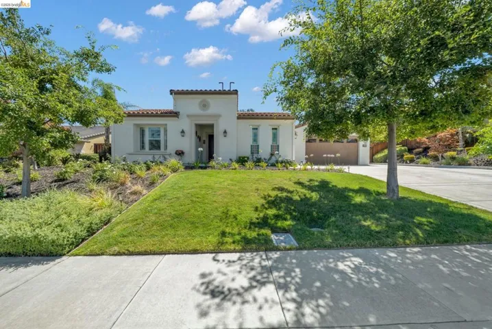 Mediterranean-style residence featuring a stucco exterior, tile roof, and a prominent front entry with decorative trim