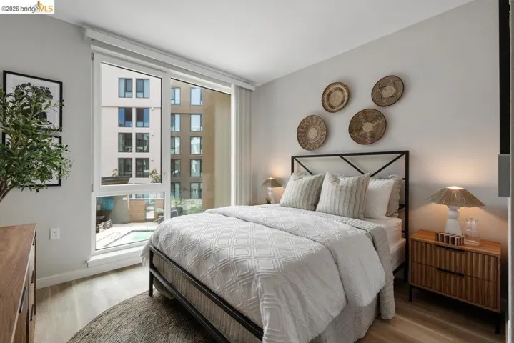 Bedroom with light wood-type flooring and lofted ceiling
