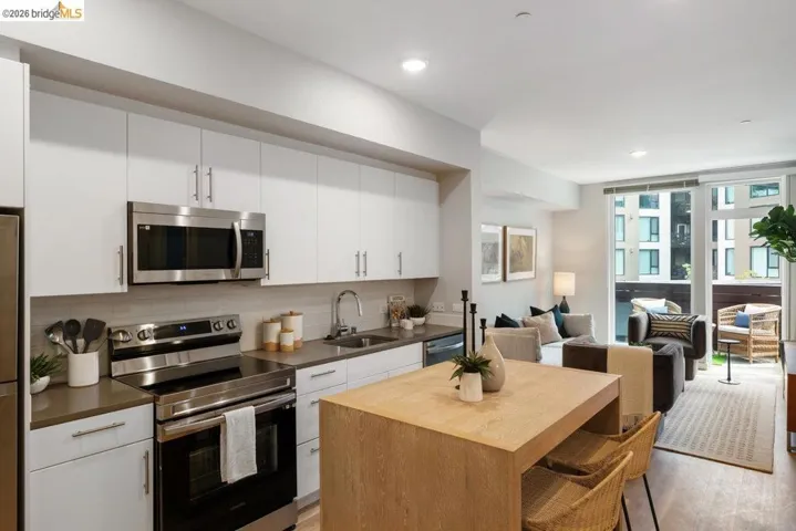Kitchen with stainless steel appliances, decorative backsplash, open floor plan, white cabinets, and recessed lighting