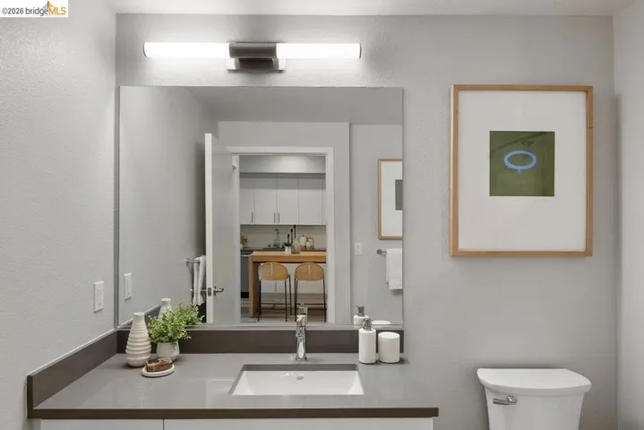 Half bathroom with a textured wall and vanity