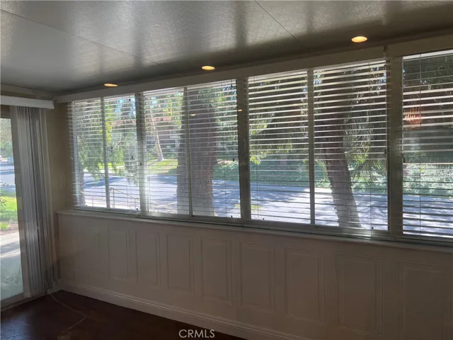 The enclosed patio room offers lots of light and fresh air through a wall of screened windows and a sliding glass door to the front walk.