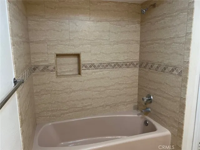 The hall bathroom has a tub with shower above and a lovely custom tile tub surround.