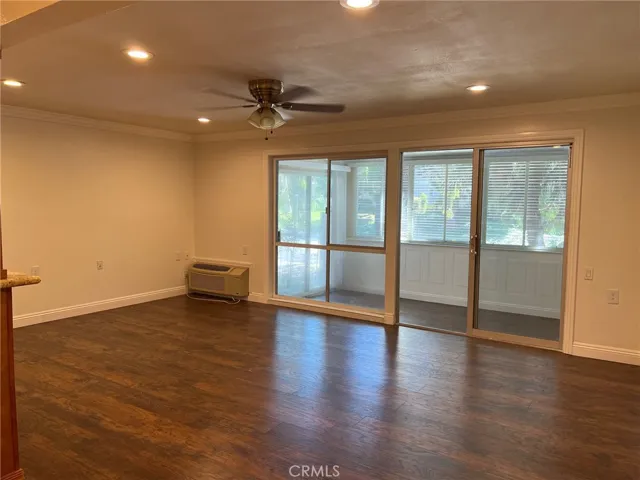 Large living room has a smooth ceiling, crown molding, a ceiling fan and recessed lighting.