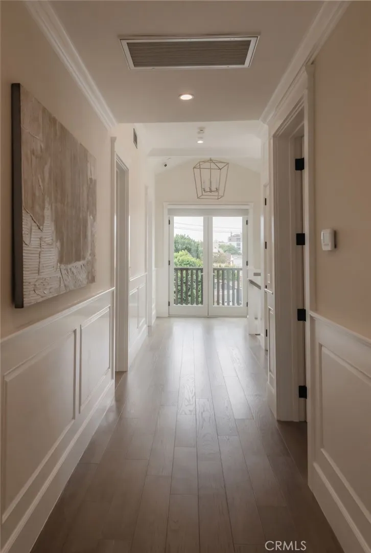 South facing from the top floor hall. French doors open to a balcony with city views