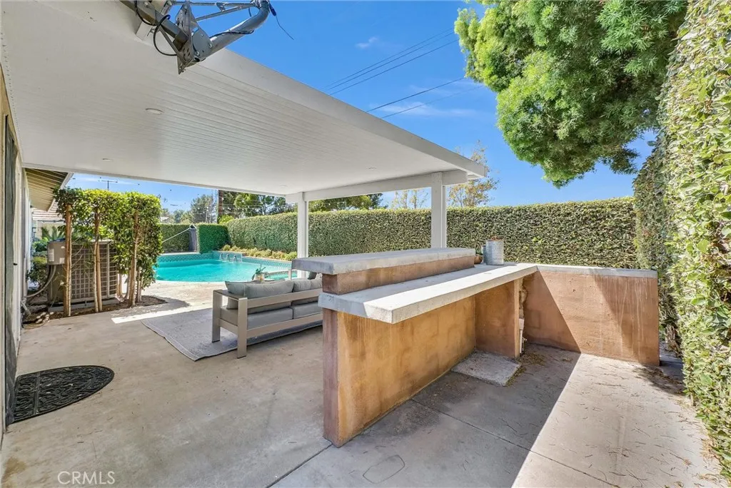 Outdoor bar, built-in BBQ with gas and power, and a covered patio for shade.
