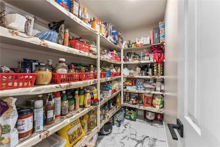Spacious walk-in pantry offering extensive built-in shelving for storage.