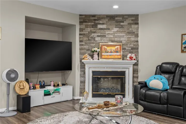 Cozy living room featuring a beautiful stone-accented fireplace.