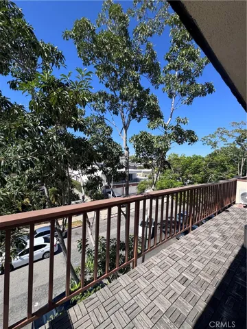 Lush trees and street view from balcony off the second bedroom