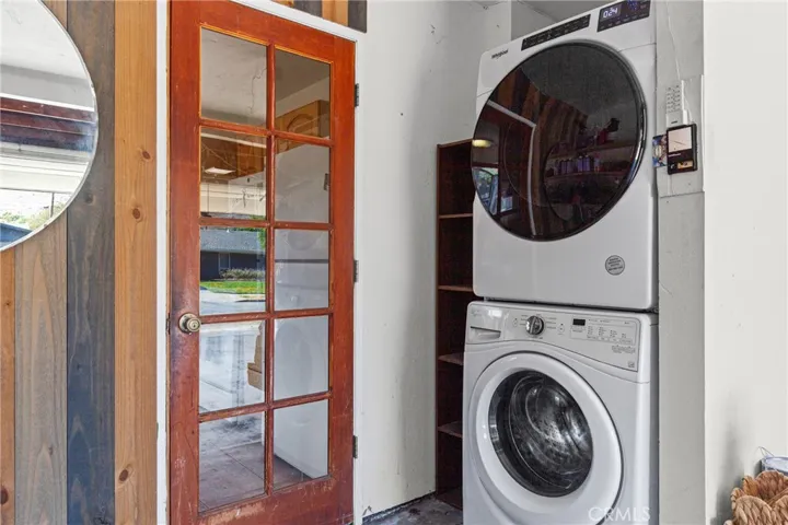 Full sized stackable washer and dryer in garage near kitchen entry