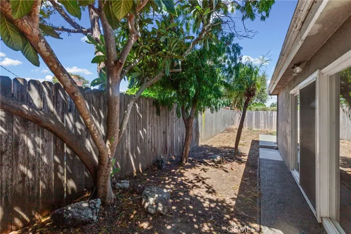 Rear yard with mature trees and privacy fence