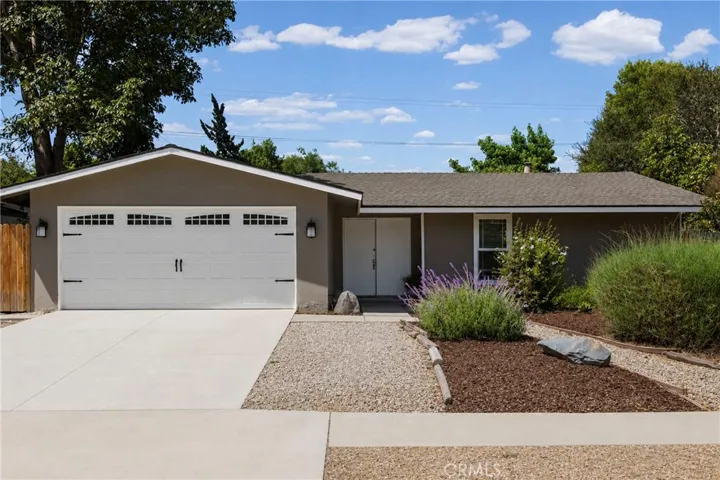 Front of home with mature landscaping and ample parking