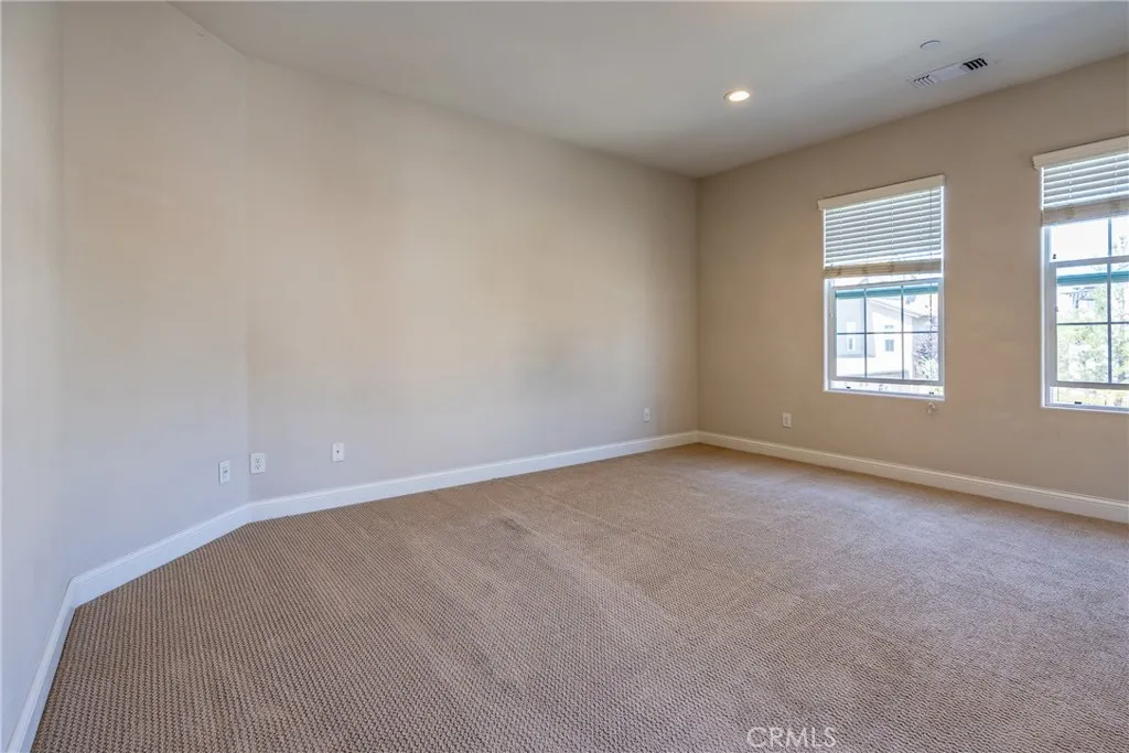 The primary suite has large windows which create a bright, inviting atmosphere.