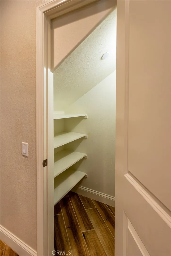 Connected to the kitchen is a walk-in pantry with shelving and light.
