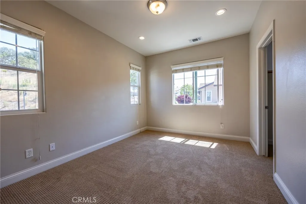 Bedroom 2 has plush carpet and multiple windows.