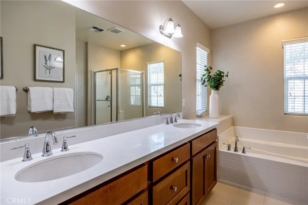 The ensuite bathroom boasts a large dual sink vanity and mirror.