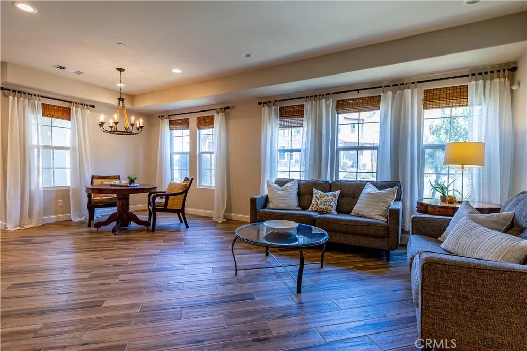 The living room is bathed in natural light thanks to the multiple windows.