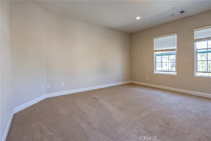 The primary suite has large windows which create a bright, inviting atmosphere.