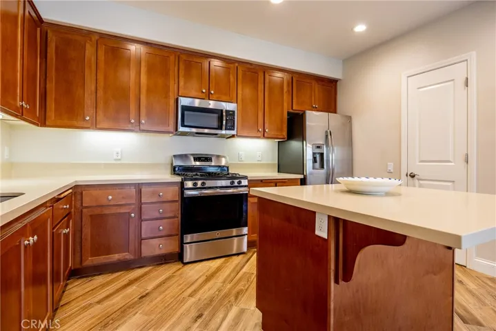 Stainless steel appliances and recessed lights brighten the kitchen. The refrigerator stays!