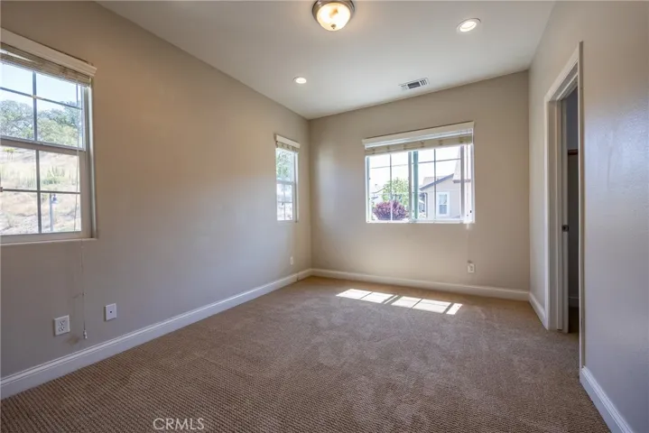 Bedroom 2 has plush carpet and multiple windows.