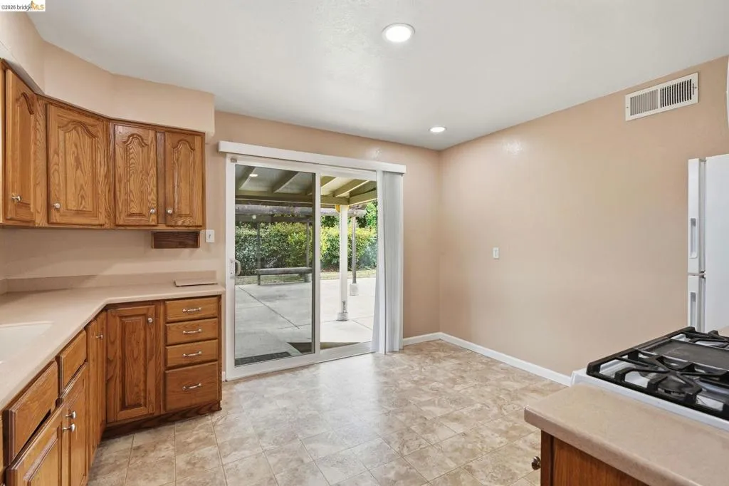 Kitchen featuring wood cabinetry, solid surface countertops, and recessed lighting