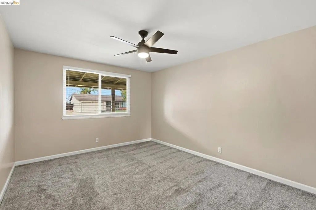 Neutral-toned walls complement the gray carpeting