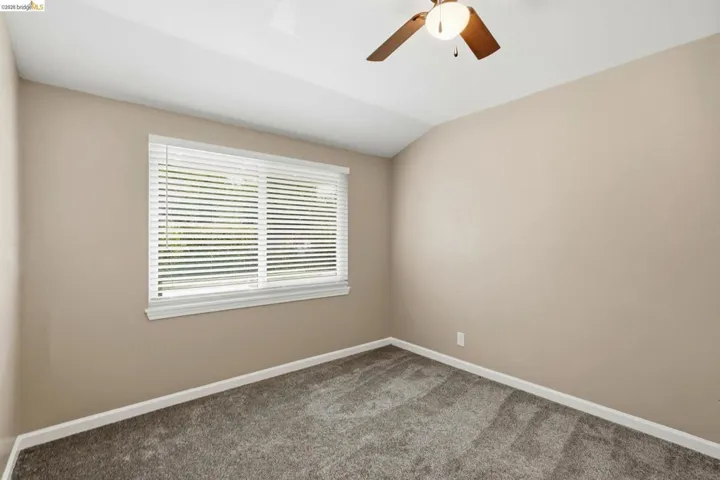 Neutral wall color, window with blinds, ceiling fan, carpet flooring, and white trim