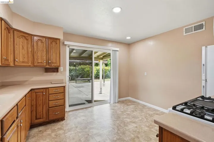 Kitchen featuring wood cabinetry, solid surface countertops, and recessed lighting