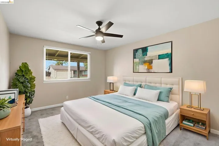 Bedroom featuring neutral wall colors, grey carpet, a ceiling fan with integrated lighting, and a large window with​​‌​​​​‌​​‌‌​​‌​​​‌‌​​​‌​​‌‌​​‌‌​​‌‌​​​​ blinds