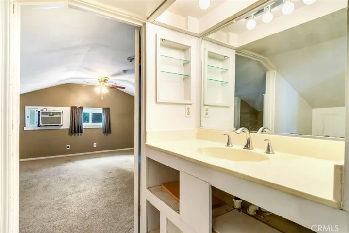 Attic Half Bathroom with Sink and Mirror
