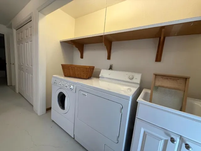 The laundry area w/ sink can be concealed behind doors; nearby is a door to the backyard clothesline
