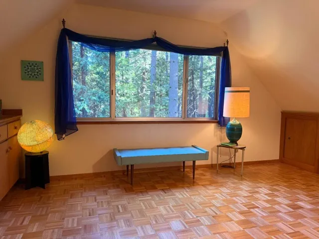 This upstairs bedroom has the same parquet floor as the living room, and storage along either side