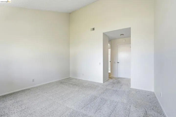 Spacious interior room with light-toned carpeting and neutral wall finishes