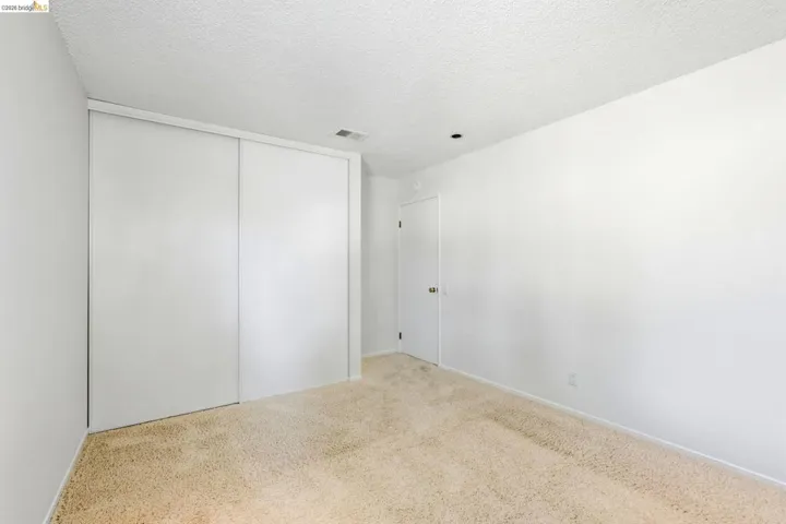 Room featuring light beige carpet, white walls, and a white ceiling