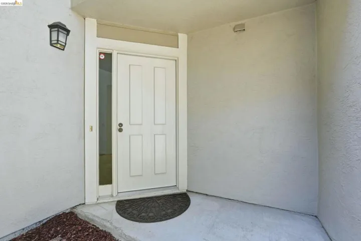 Exterior entry featuring a paneled door, transom window, and a side light