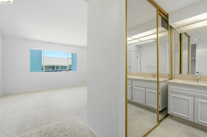 Dual vanity with light-toned countertops and white cabinetry