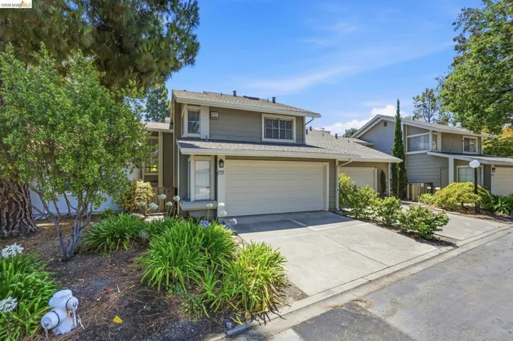Contemporary multi-story residence featuring a two-car garage, concrete driveway, and a front entry with adjacent landscaping