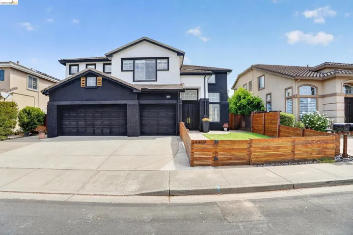 Two-story residence featuring a contemporary black and white exterior with a two-car garage
