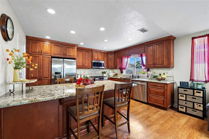granite countertops, a large center island with wrap around bar seating